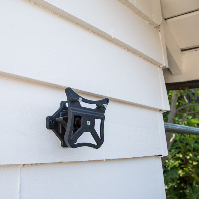 mounting braket installed on the site of a house with white siding